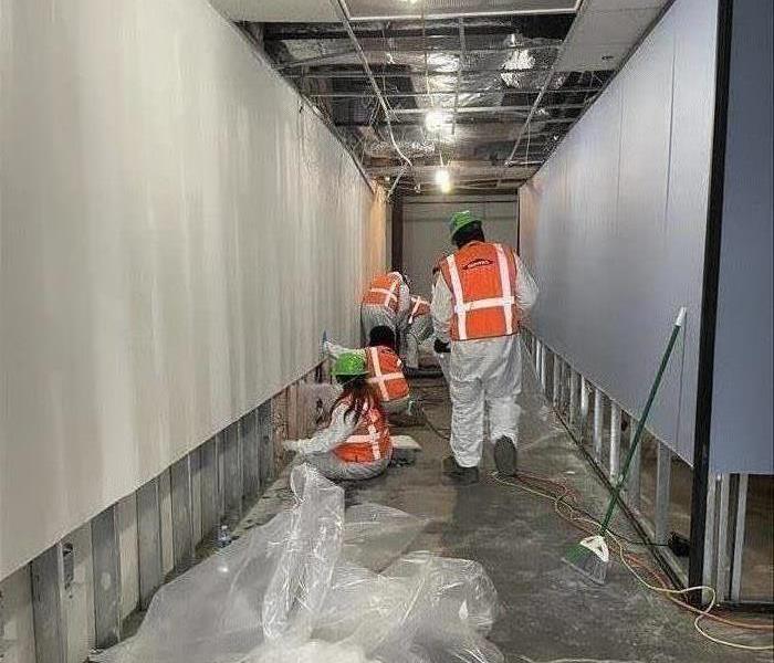 SERVPRO crew removing water-damaged dry wall